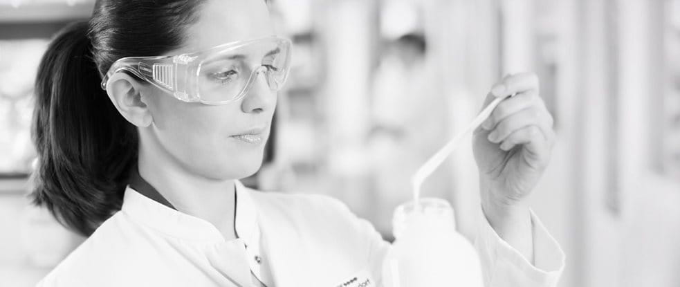 Chercheuse avec des lunettes de sécurité testant une formule