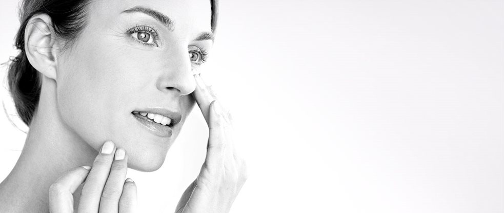 Femme appliquant de la crème sur son visage.