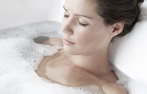 Femme relaxant dans un bain moussant