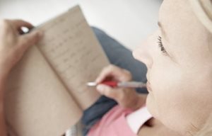 Femme écrivant dans son carnet de notes.