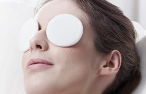 Femme relaxant avec des pansements sur les yeux.