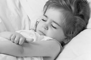 Petite fille grattant le creux de son bras.