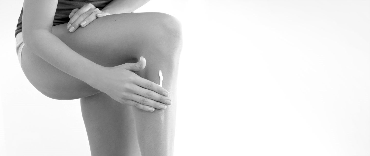 Femme touchant sa jambe gauche